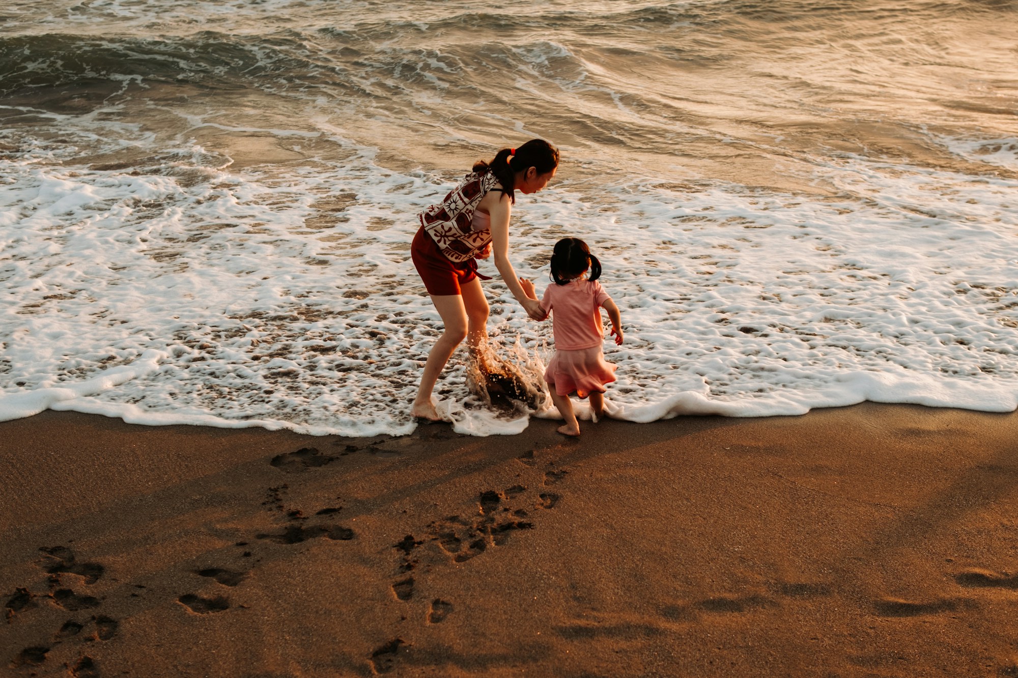 Mother and daughter walking together at the beach